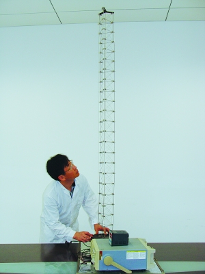這是伸展開(kāi)的衛星太陽(yáng)能電池用盤(pán)壓伸桿，20厘米長(cháng)螺旋狀的盤(pán)壓伸桿（右側小圖）打開(kāi)后能達2米長(cháng)（8月7日攝）。（新華社發(fā)）