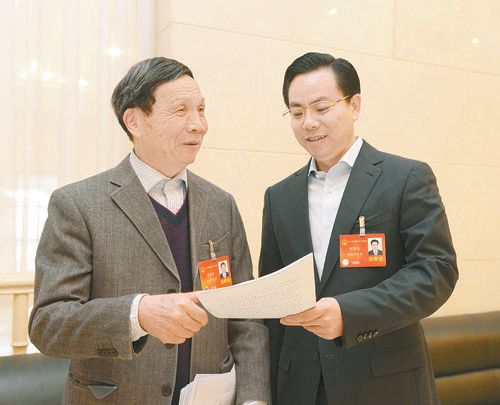 黃伯云代表（左）與劉國忠代表商討完善《關(guān)于建立戰略性新興產(chǎn)業(yè)國家創(chuàng  )新平臺》的建議。 本報記者 張目 攝